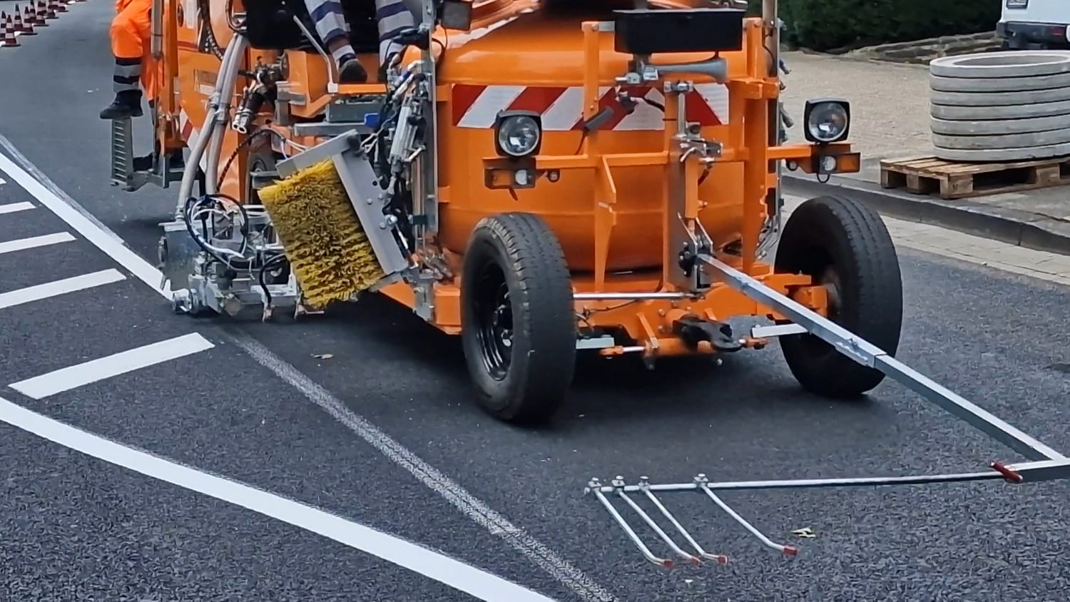 Fahrbahnmarkierungen werden von einem Arbeitsfahrzeug auf Asphalt aufgetragen